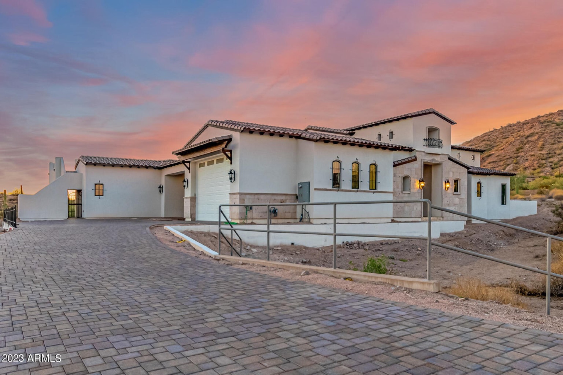 Large travertine paver patio with fire pit — North Scottsdale project by Turfli